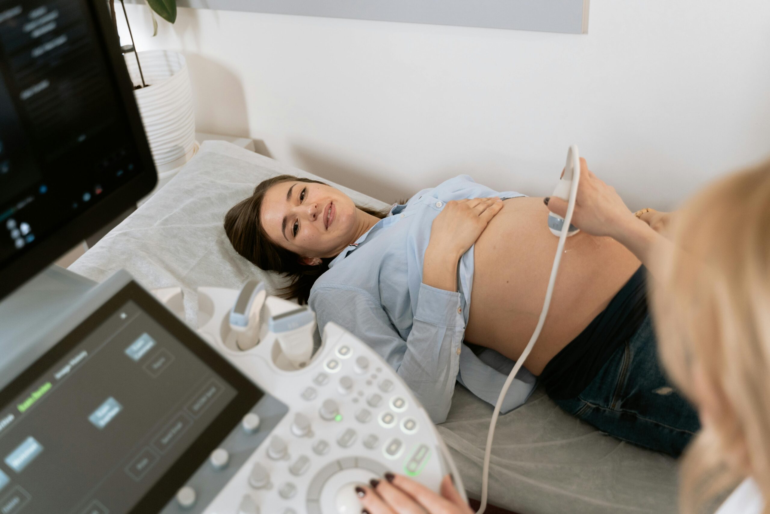 A pregnant woman getting an ultrasound at the hospital or OB/GYN office.